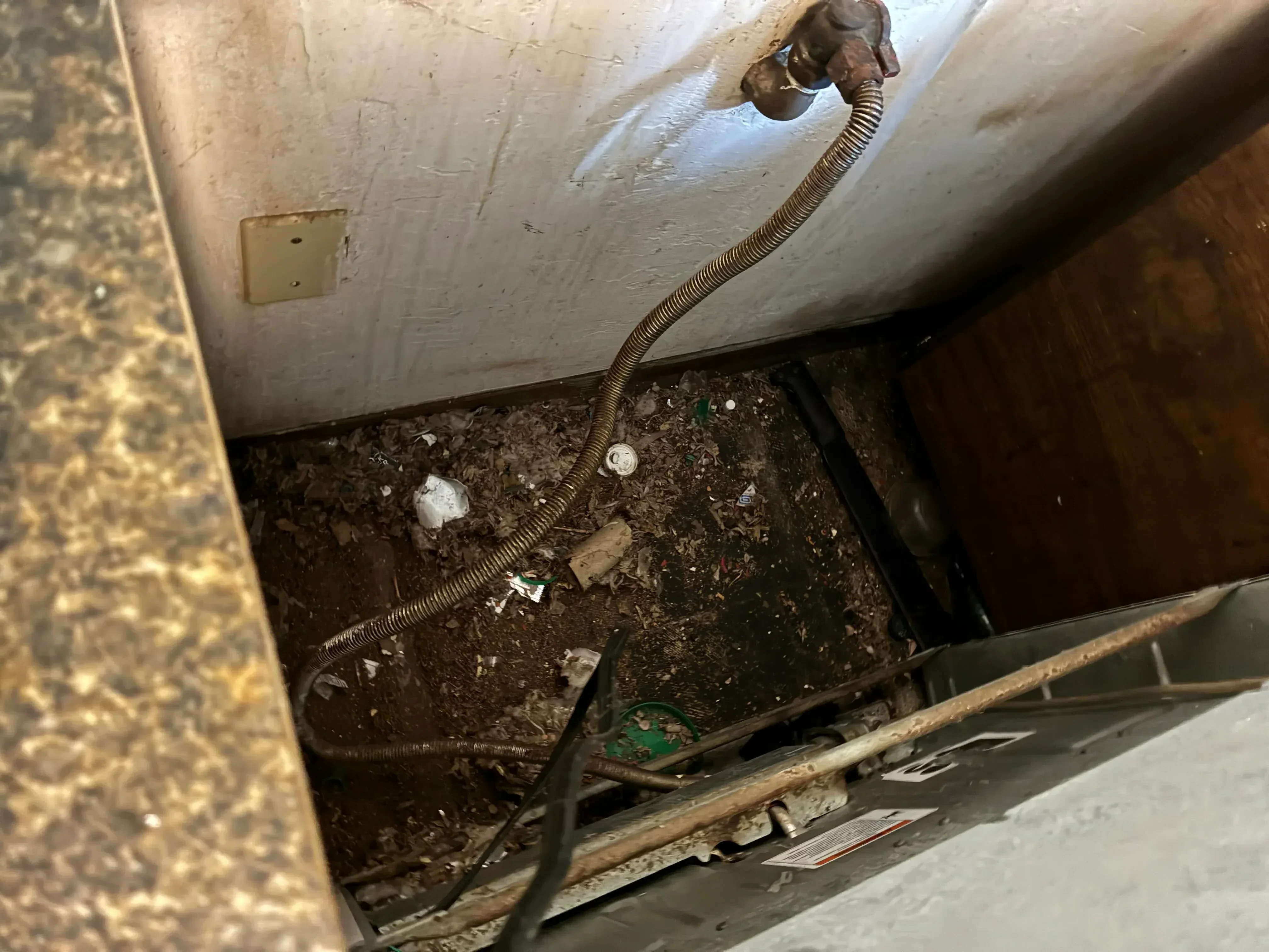 Old drain line removed, new flexible conduit installed in wall cavity with metal fittings