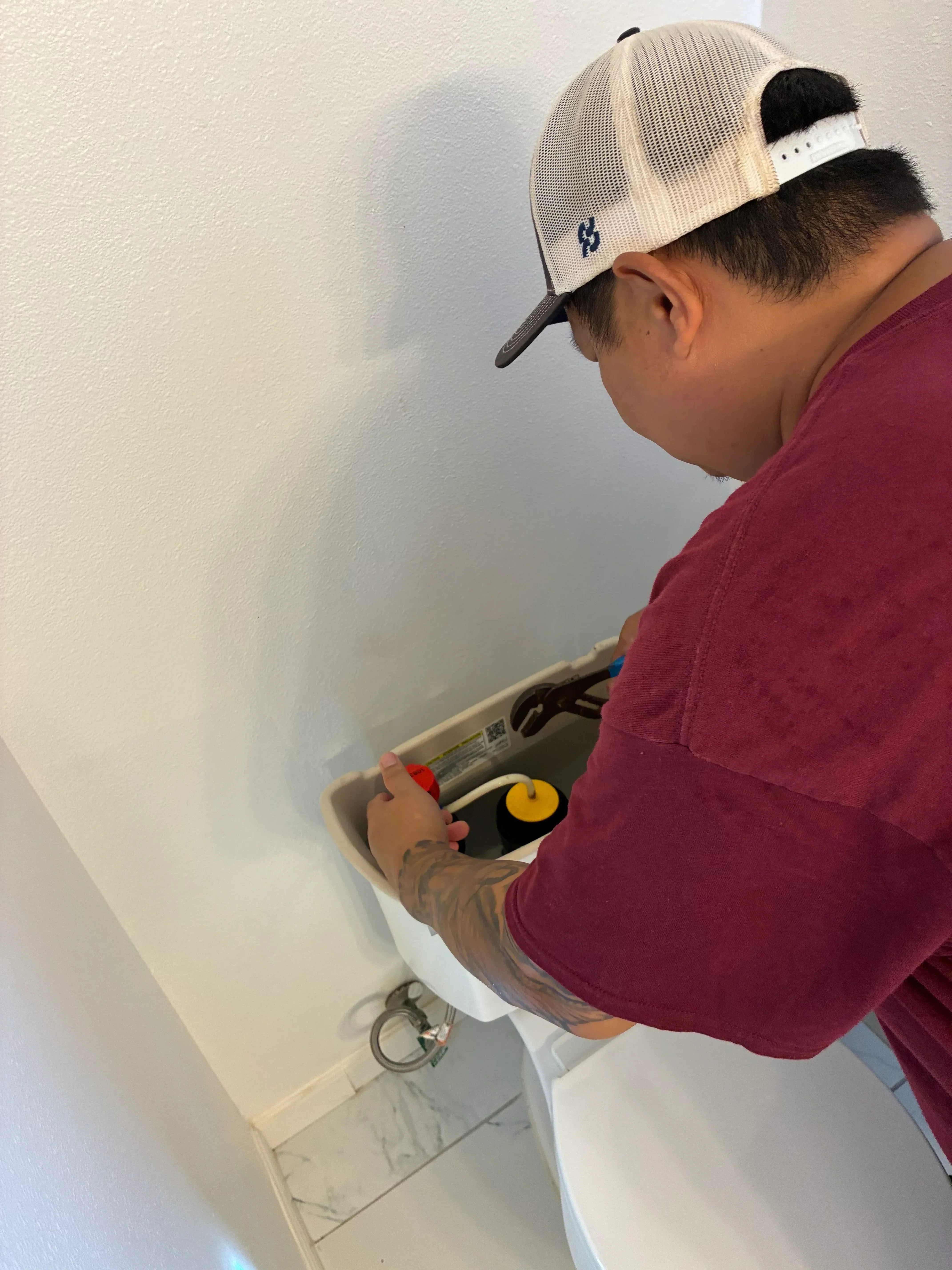 Plumber installing bathroom sink valve and supply line connections