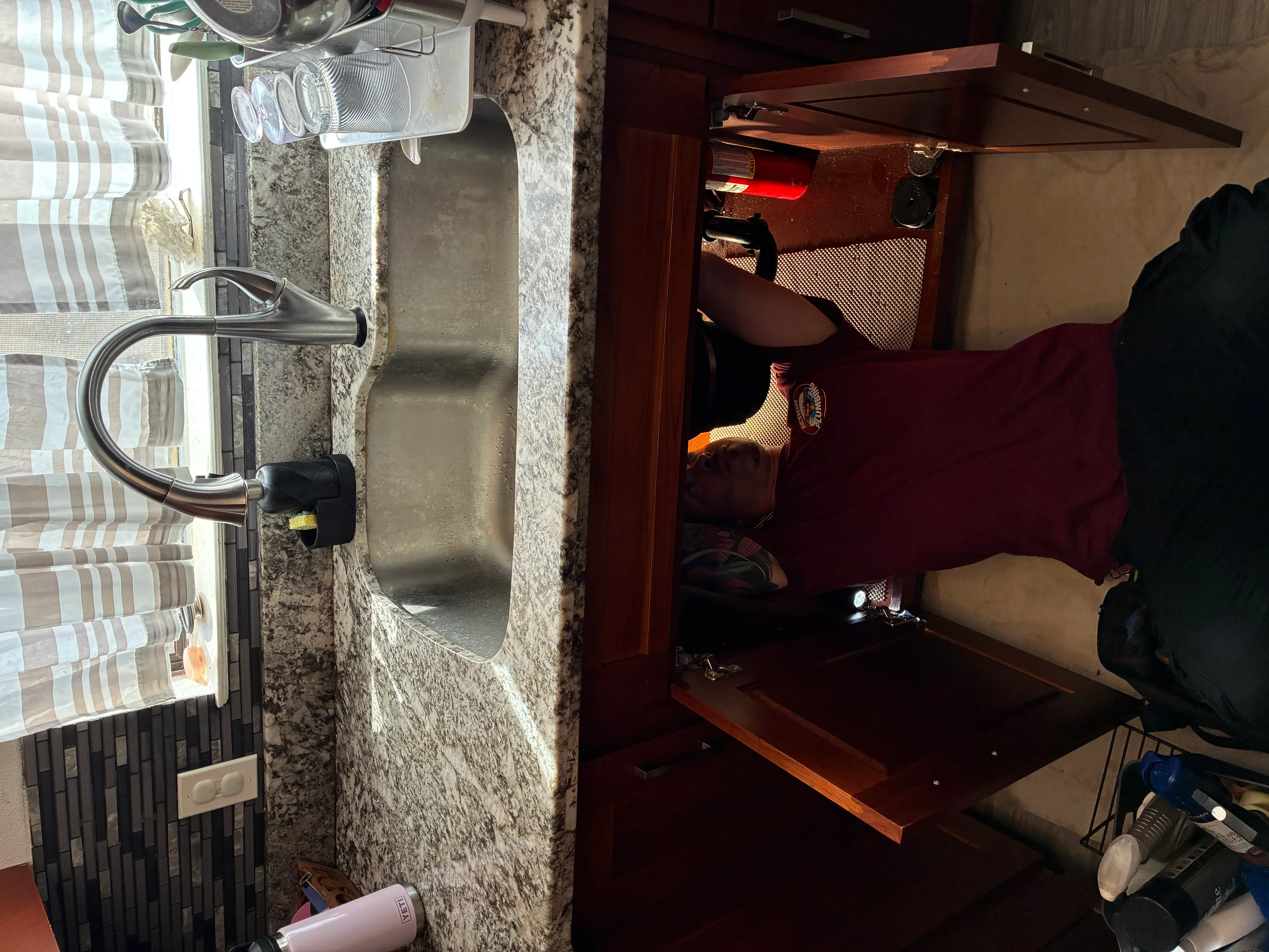 Chrome faucet installed on granite bathroom sink with supply lines connected