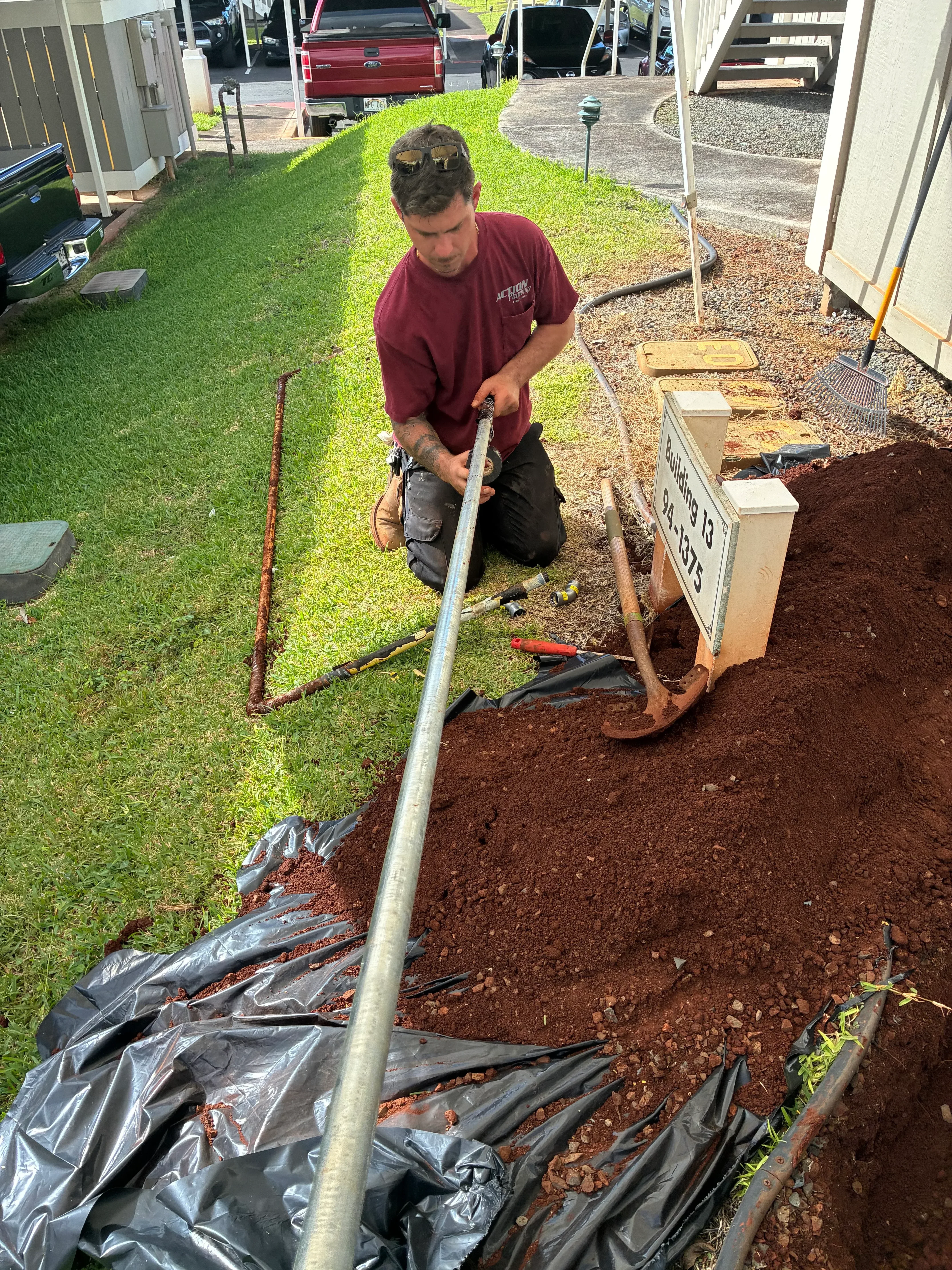 Sewer line excavation with deep trench, exposed soil, and underground pipe access during repair work