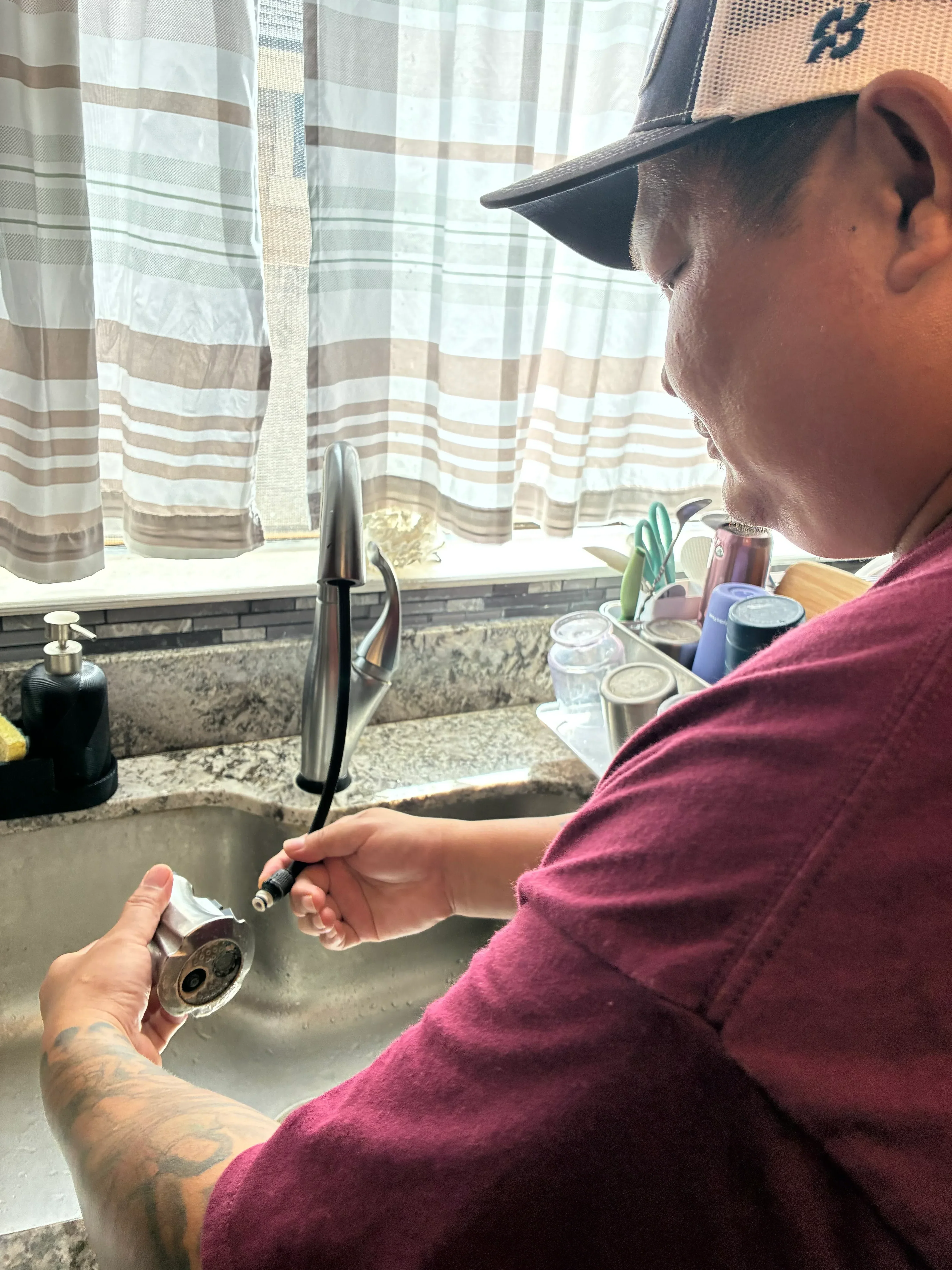 Plumber repairing faucet fixture with internal components and hardware visible